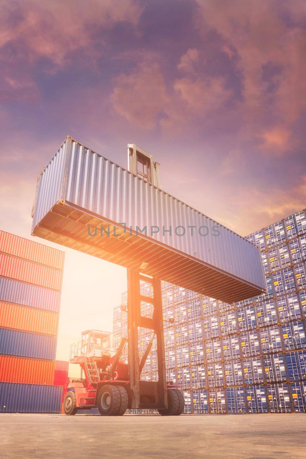 Forklift truck lifting cargo container in shipping yard for transportation import,export and logistic industrial concept by Nuamfolio