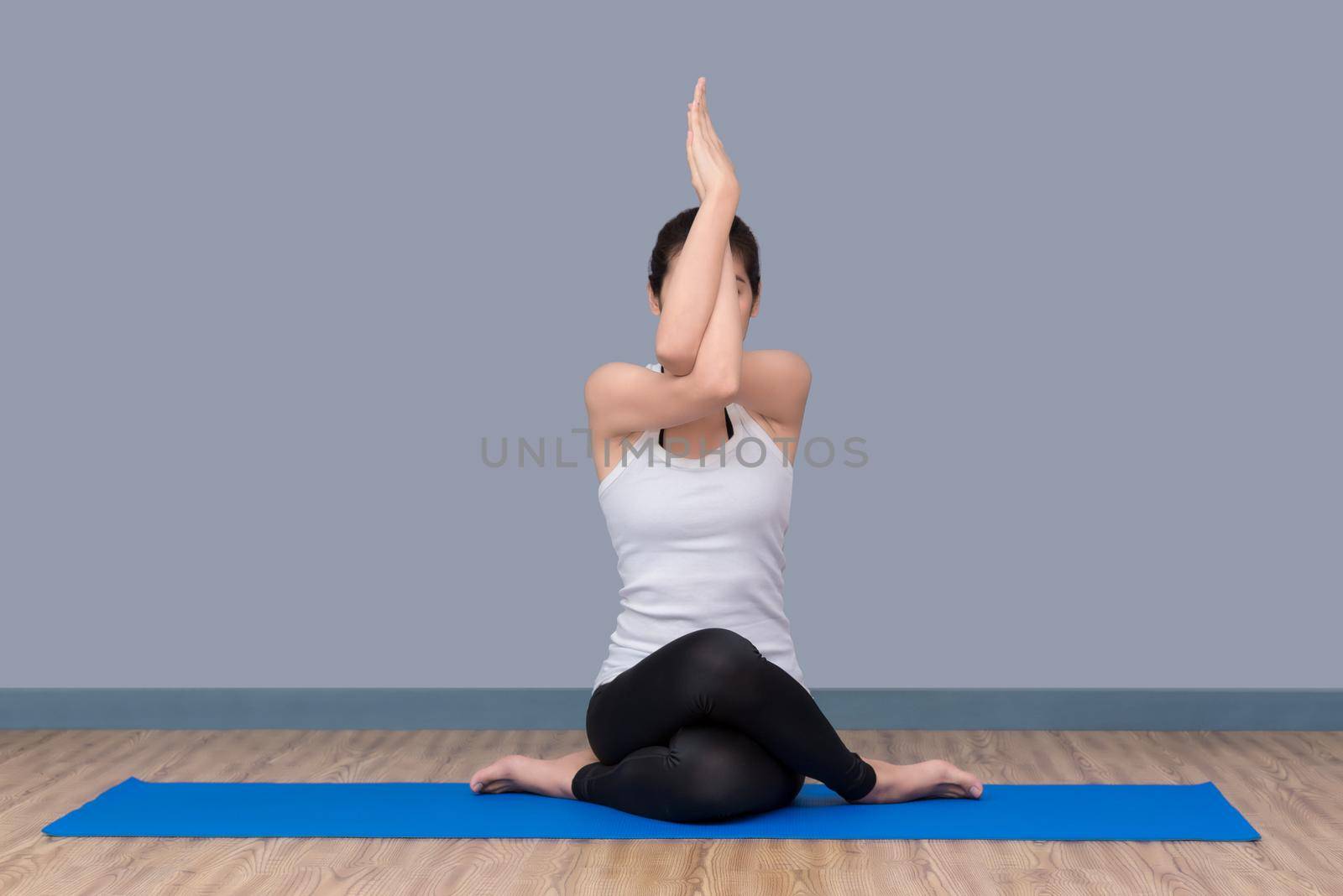 Healthy woman exercising yoga at sport gym, girl doing sport indoor.Photo design for fitness sporty woman and healthcare concept. by Nuamfolio