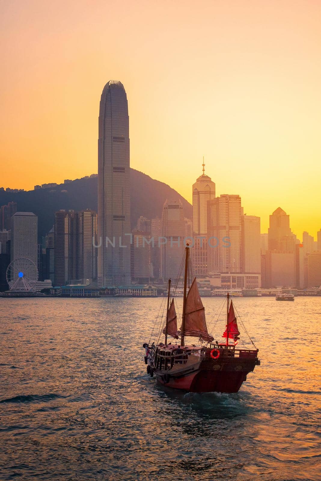 Hong kong traditional wooden chinese boat for tourist service in victoria harbor at sunset view from Kowloon side at Hong Kong  by Nuamfolio