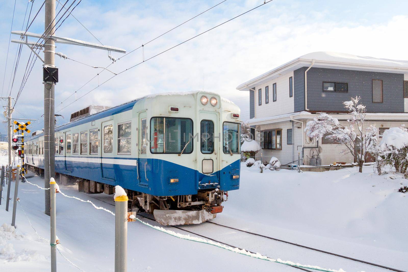Train moving on railway track for local train with white snow fall in winter season,Japan by Nuamfolio