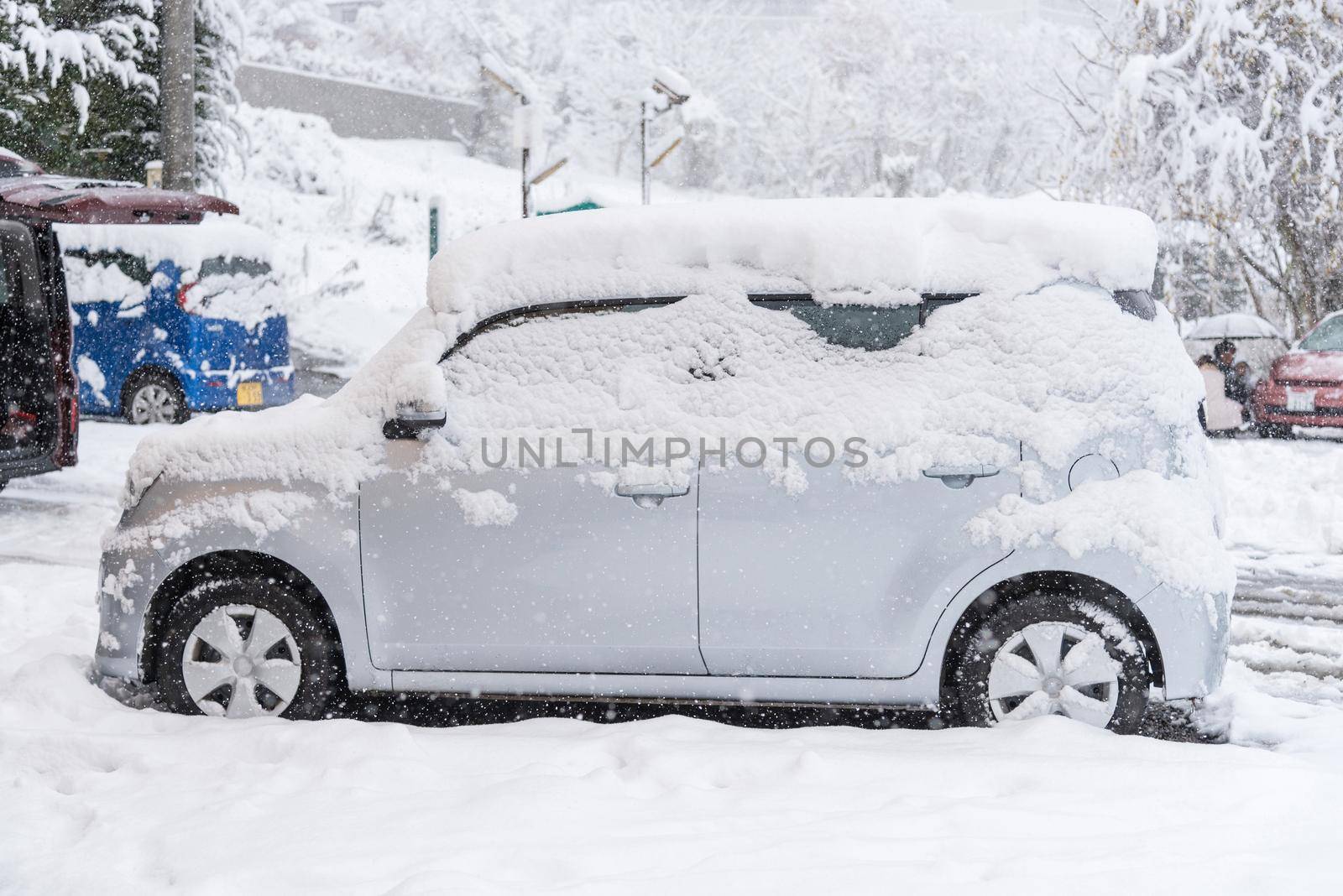 Fresh white snow falling at public park cover road and car in winter season at Kawaguchiko,Japan.