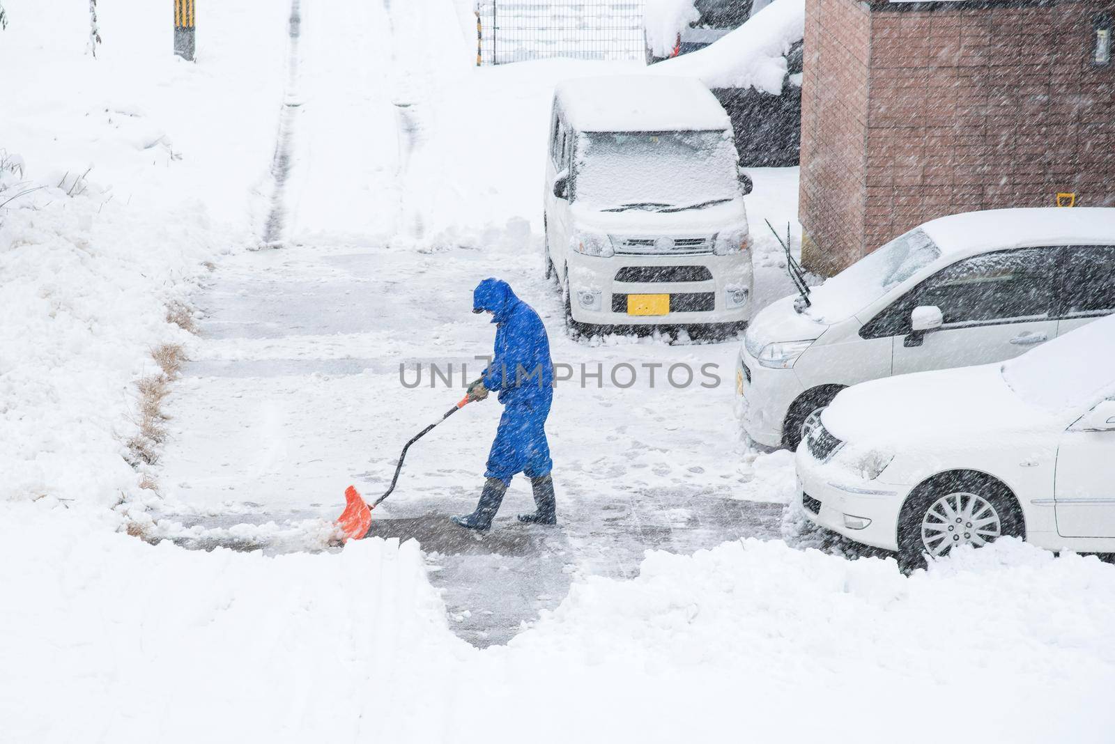 Fresh white snow falling at public park cover road and car in winter season at Kawaguchiko,Japan.