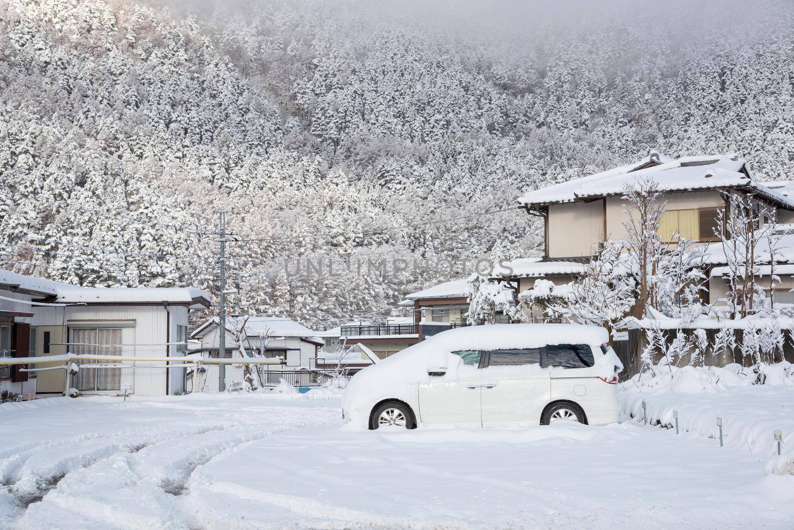 Fresh white snow falling at public park cover road and car in winter season at Kawaguchiko,Japan.