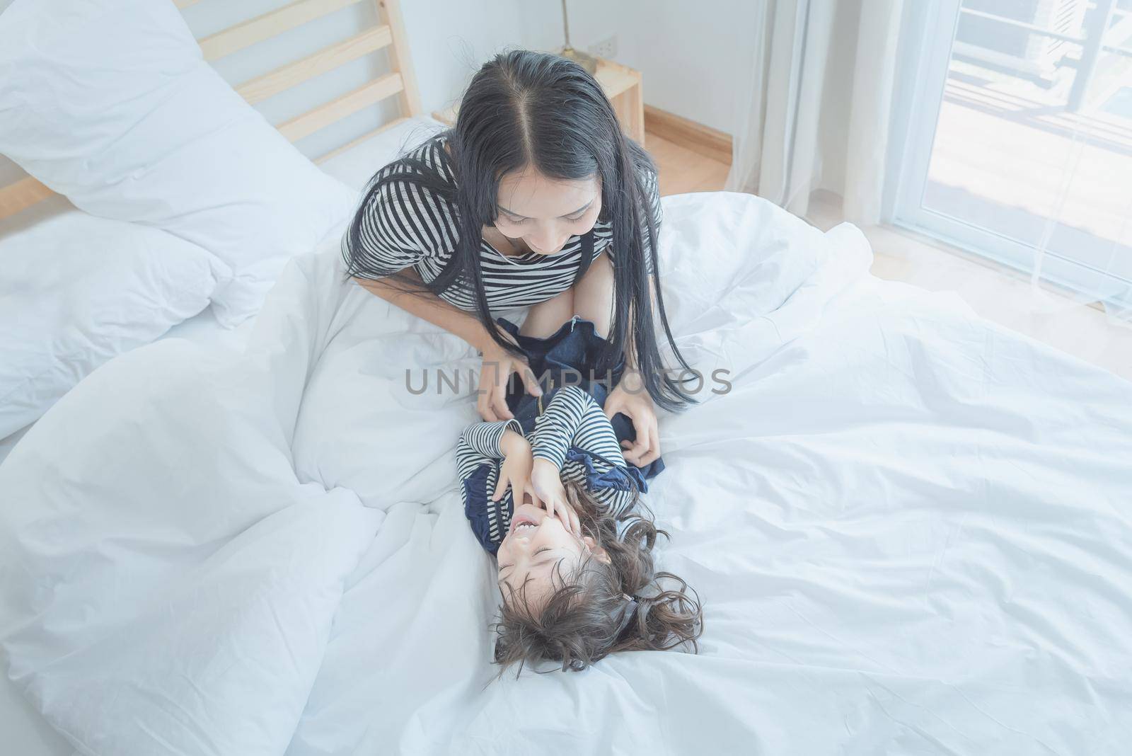 Happy loving family, Pretty young mother playing with her daughter in kid's room.Photo design for family, kids and happy people concept