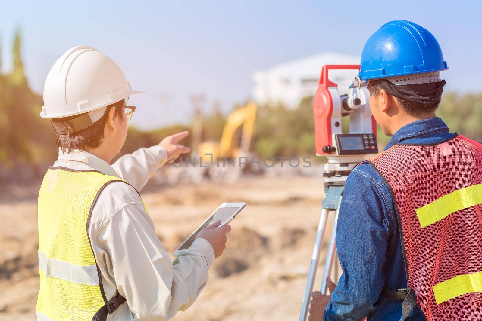 Construction engineer with smart tablet and foreman worker checking construction site for new Infrastructure construction project by Nuamfolio