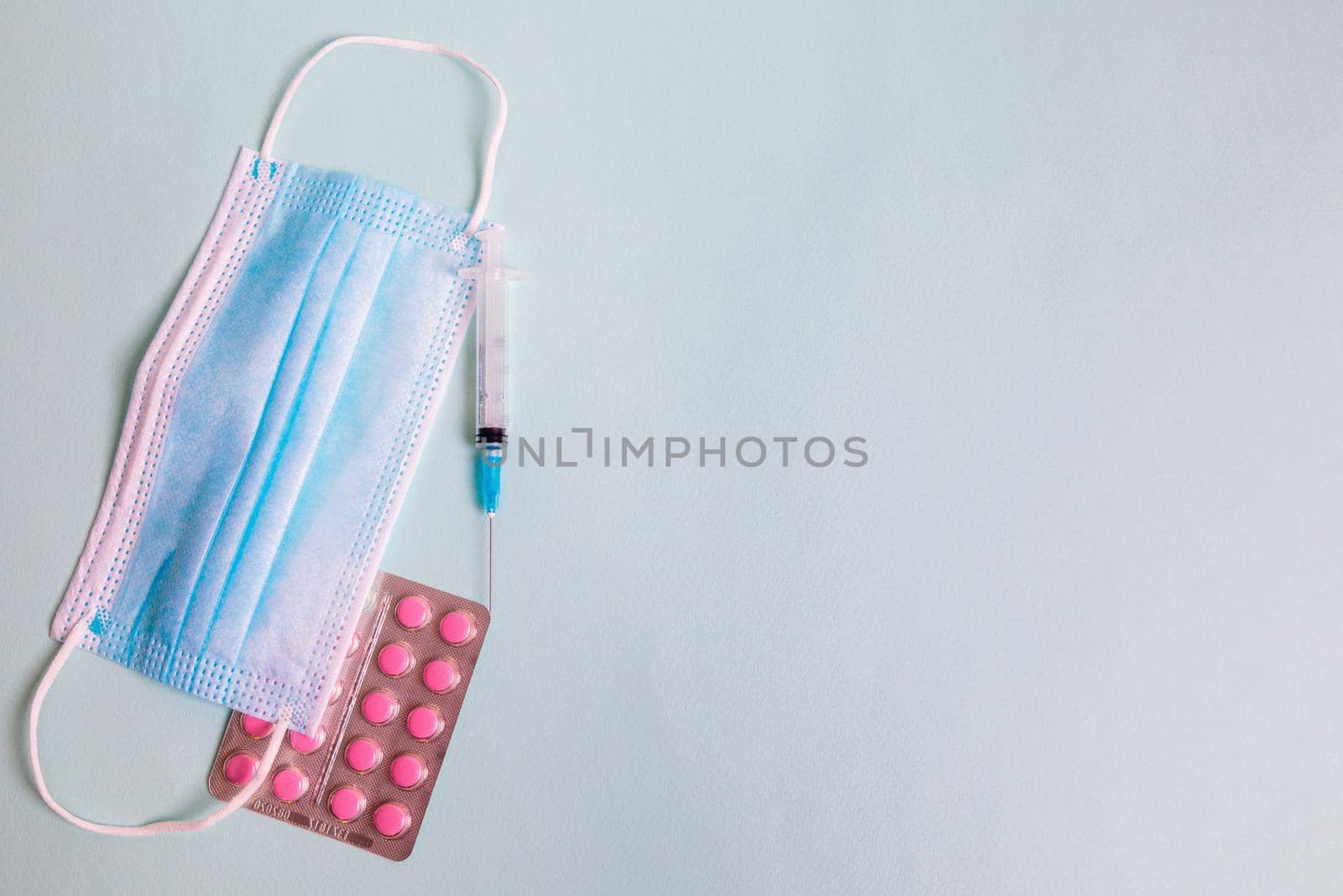 On the table is a medical mask with a syringe and medicine for coronavirus. Coronavirus quarantine concept.