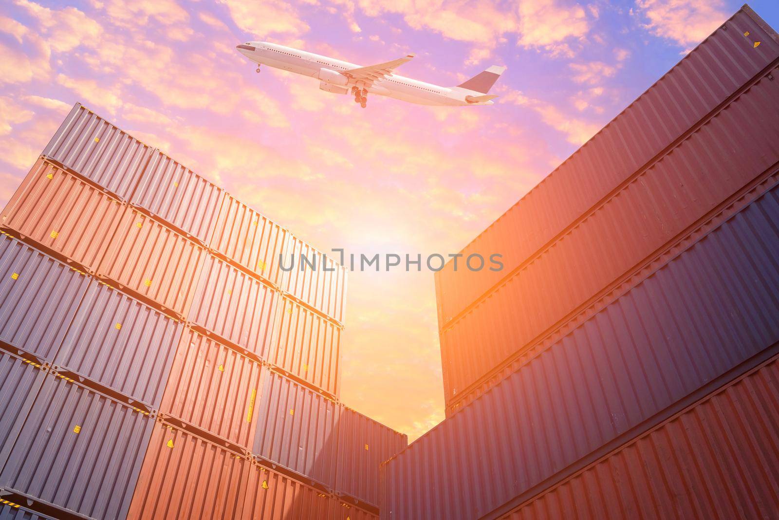 Cargo Flight flying over Colourful stack of cargo shipping containers in shipping yard.Photo concept for Global business containers shipping,Logistic,Import and Export industry. by Nuamfolio