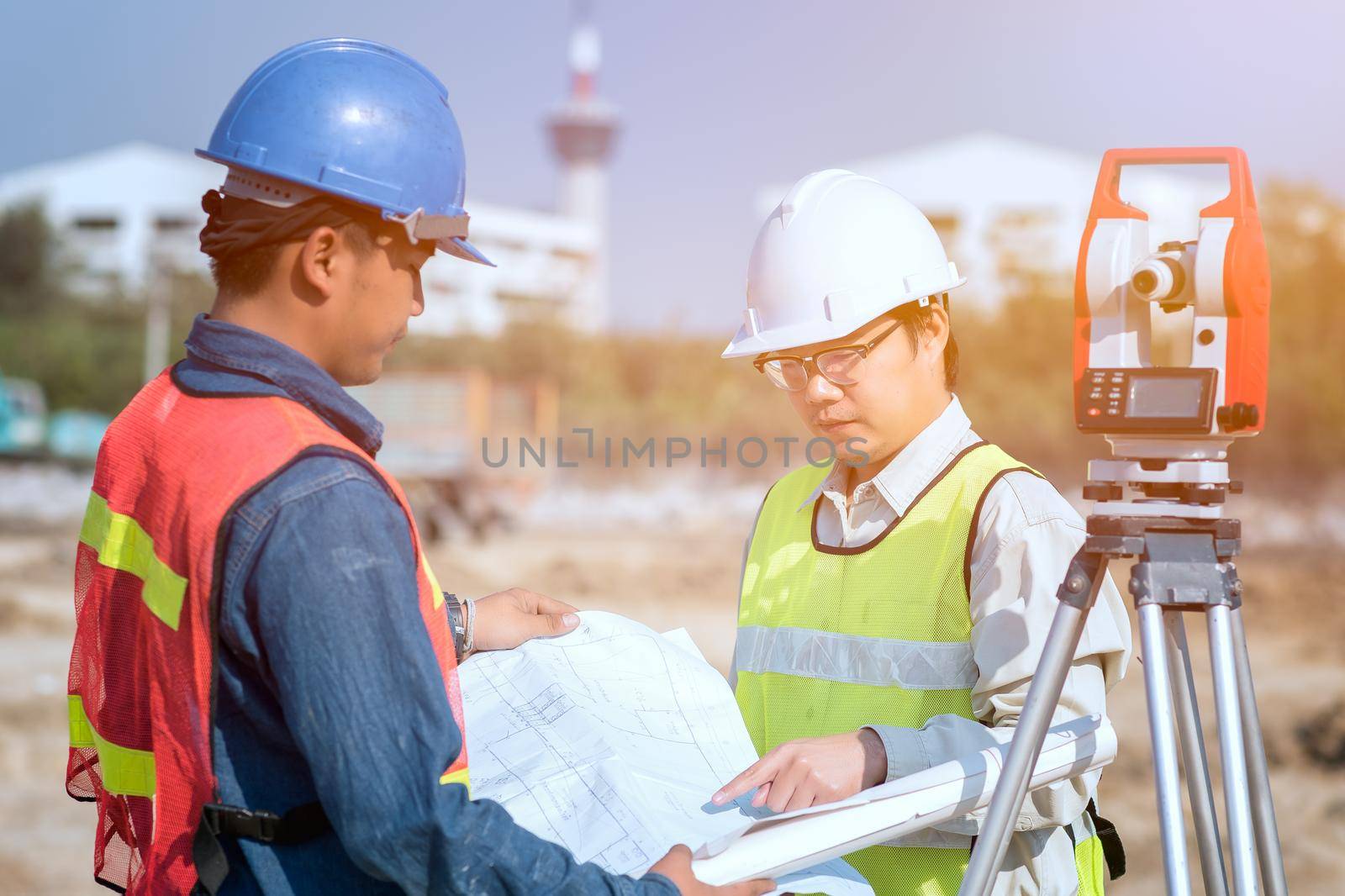 Construction engineer and foreman worker checking construction drawing at site for new Infrastructure construction project by Nuamfolio