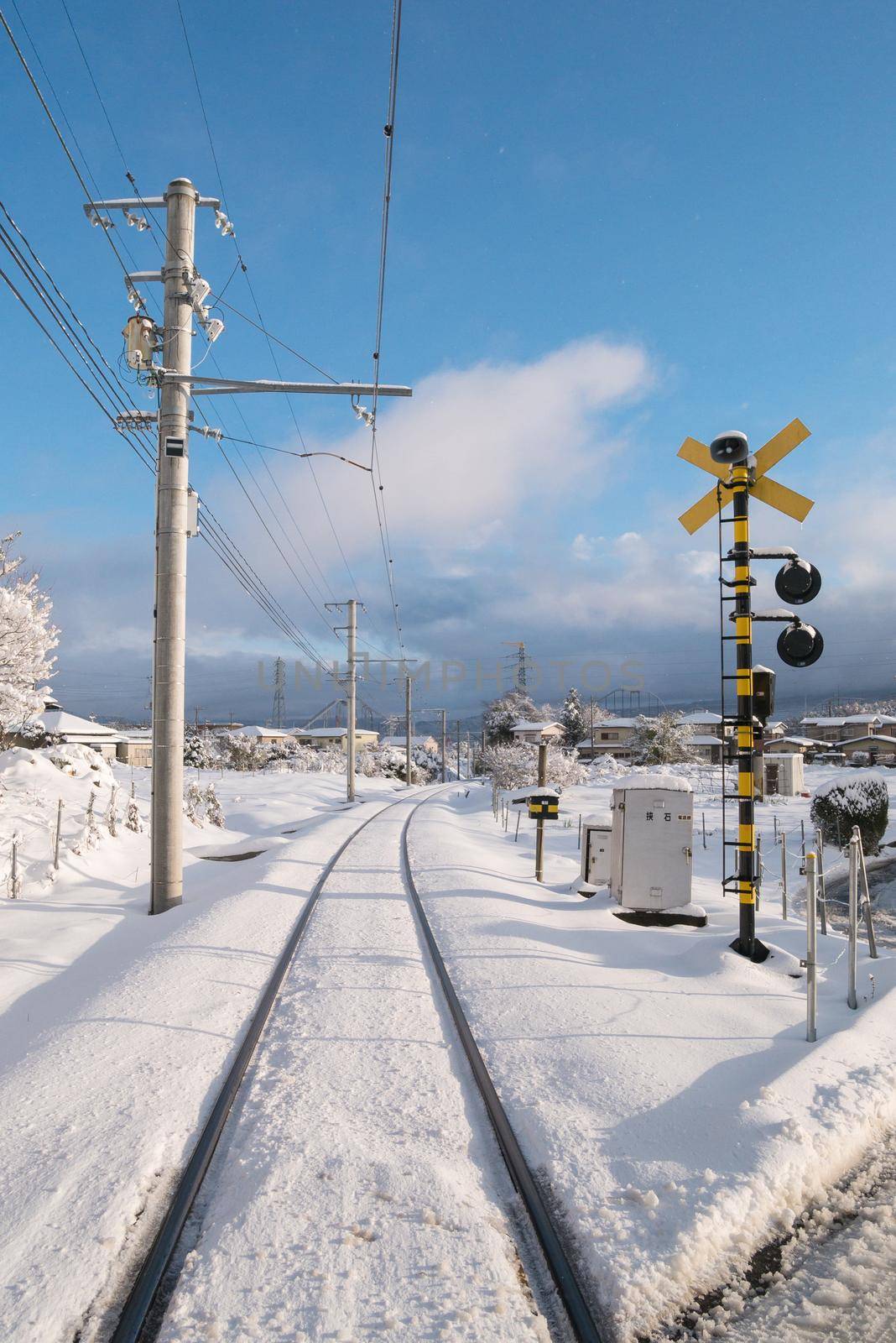 Railway track for local train with white snow fall in Japan