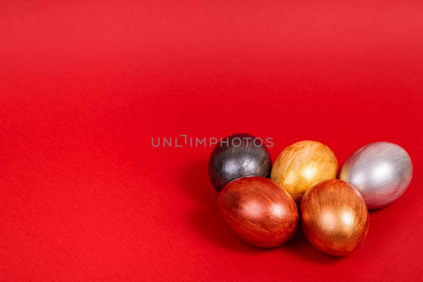 Easter. Multi-colored eggs on a uniform red background with place for text. View from above.