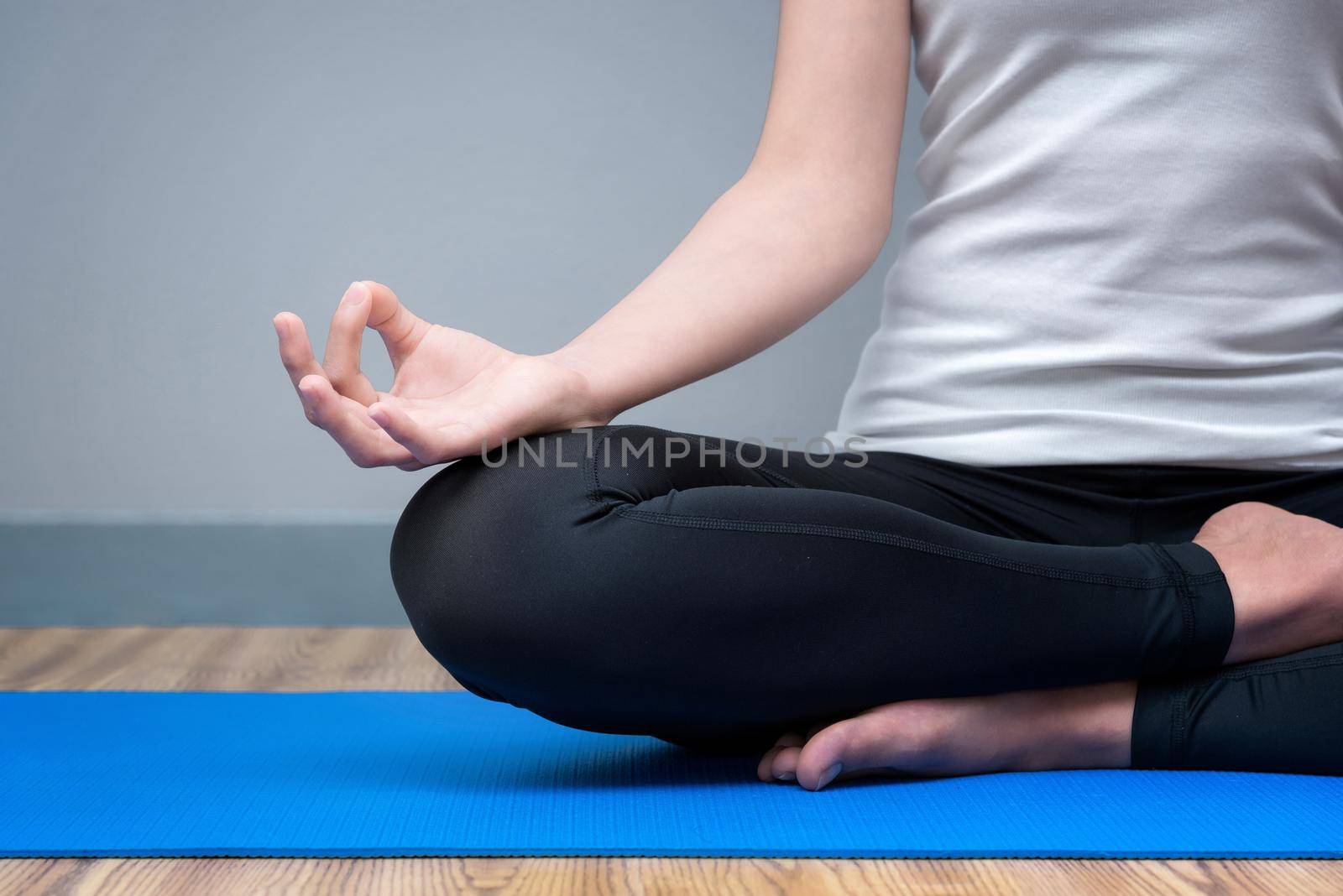 Young woman keep calm and meditates while practicing yoga to at yoga sport gym. Yoga and meditation have good benefits for health. Photo concept with copy space for Yoga Sport and Healthy lifestyle.