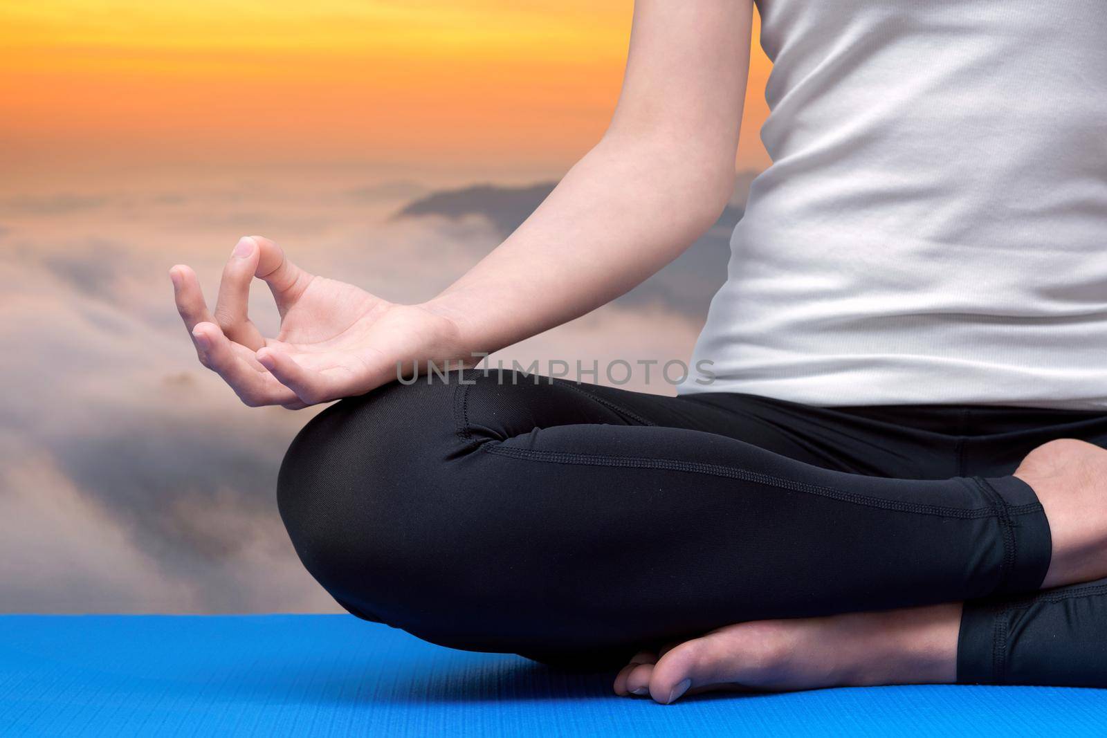 Young woman keep calm and meditates while practicing yoga to explore the Inner Peace. Yoga and meditation have good benefits for health. Photo concept for Yoga Sport and Healthy lifestyle. by Nuamfolio
