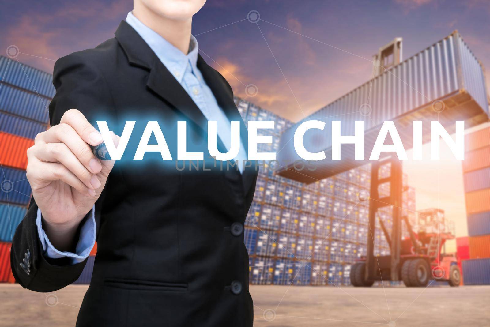 Smart business woman is writing value chain word with forklift lifting cargo container and cargo containers stack in background for global transportation import,export and logistic business concept by Nuamfolio