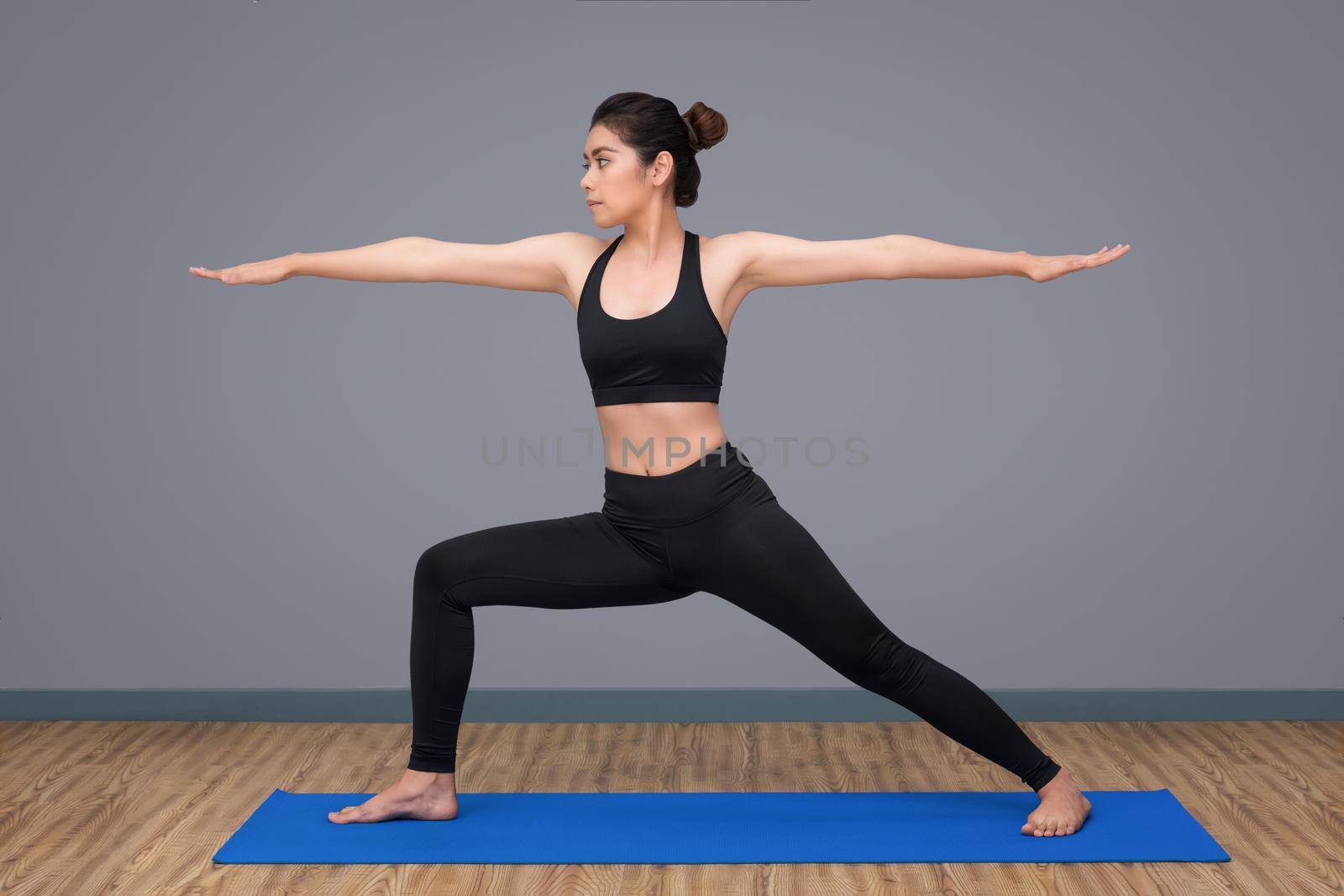 Young asian woman practicing yoga pose at yoga healthy sport gym, yoga and meditation have good benefits for health. Photo concept for Yoga Sport and Healthy lifestyle.