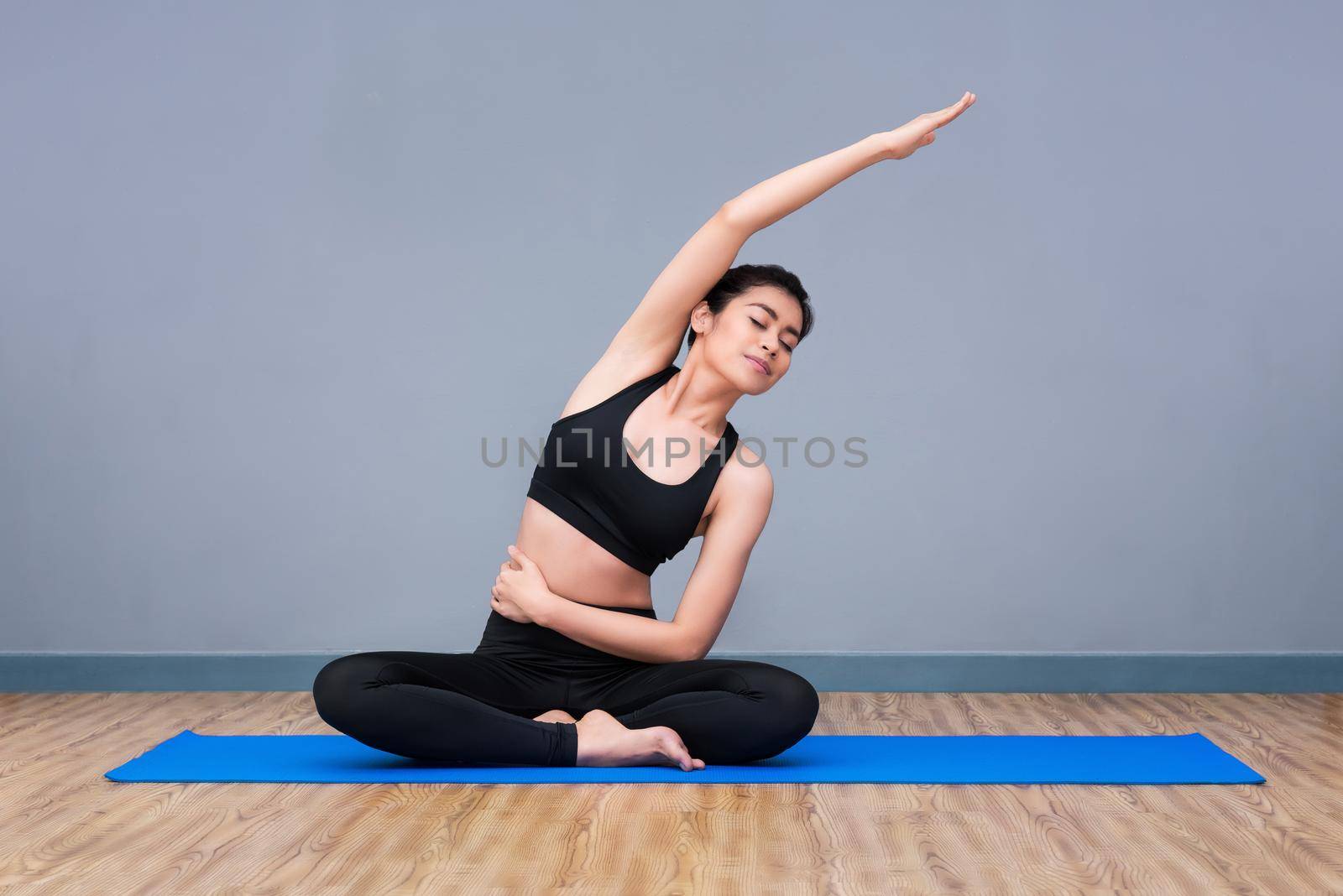 Young asian woman practicing yoga pose at yoga healthy sport gym, yoga and meditation have good benefits for health. Photo concept for Yoga Sport and Healthy lifestyle.