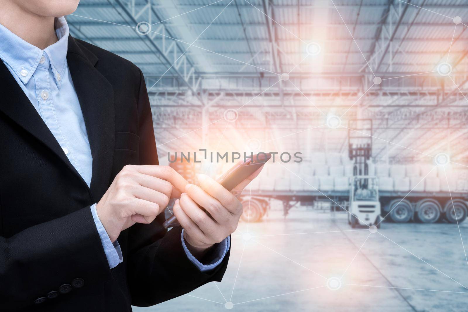 Asian business woman use smart technology of internet of things with Huge distribution shipping warehouse background.Photo concept for Global business shipping,Logistic,Import and Export industry. by Nuamfolio
