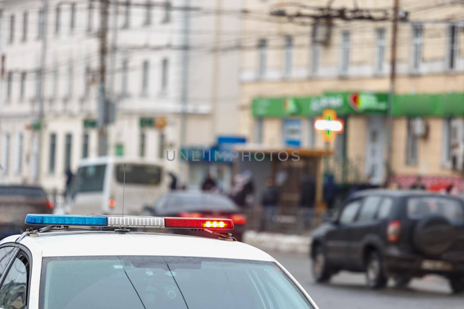 police car lights in city street with civilian cars traffic in blurry background in Tula, Russia.