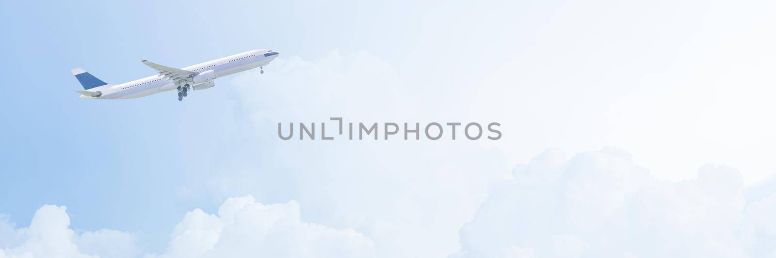 Commercial airplane flying over bright blue sky and white clouds. Elegant Design with copy space for travel concept by Nuamfolio