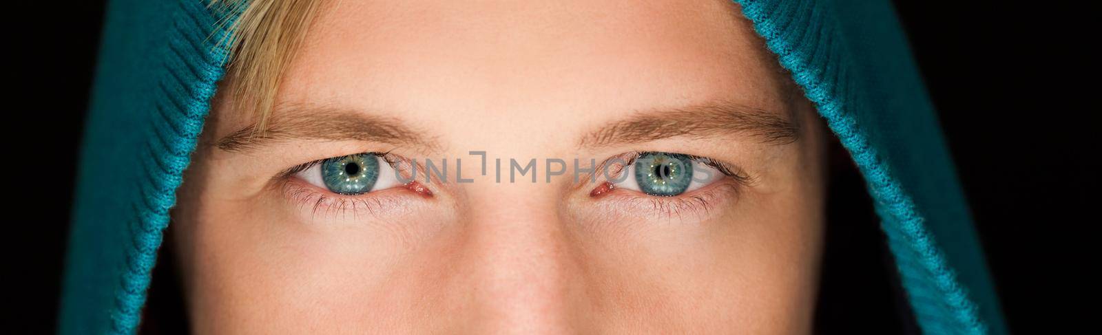 sexy young man with a hoodie ,blue eyes close up