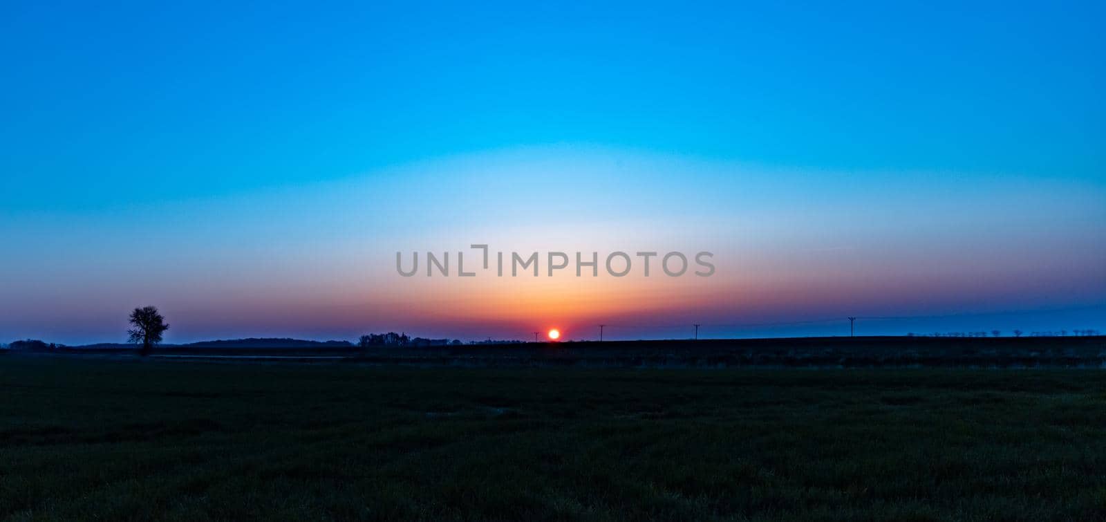 Beautiful sunrise at morning over huge green fields