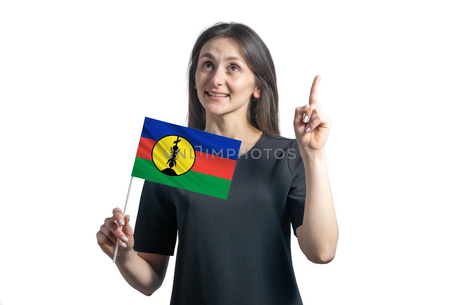 Happy young white woman holding flag of New Caledonia and points thumbs up isolated on a white background by uspmen