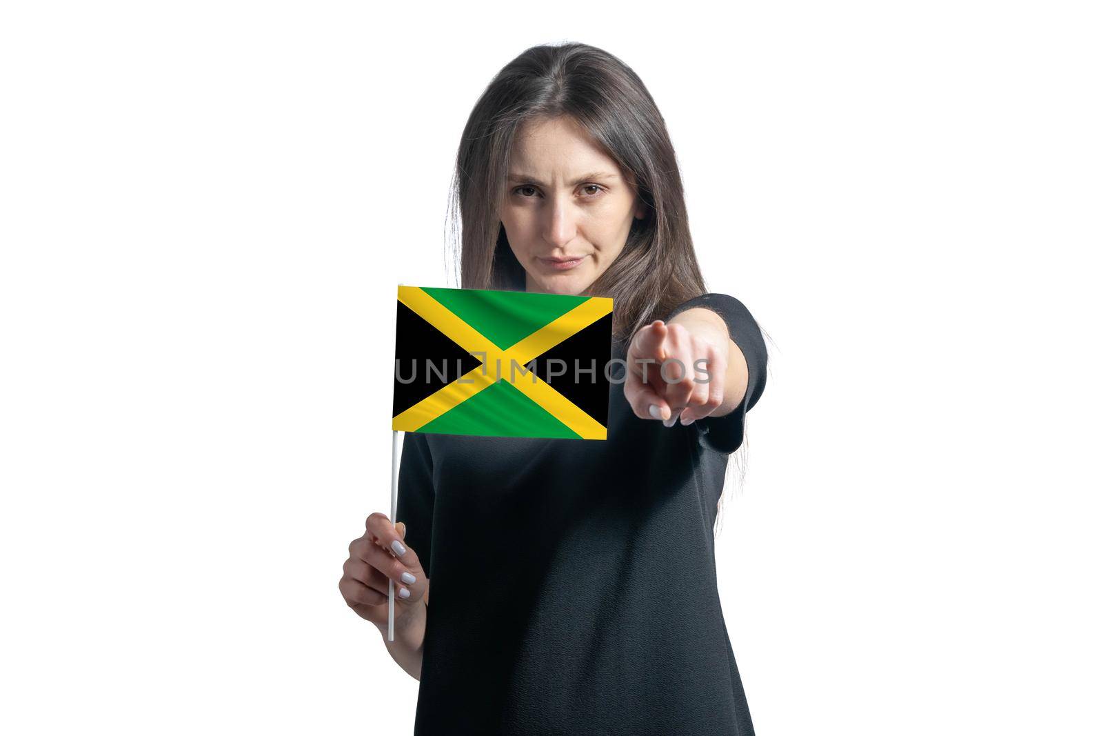 Happy young white woman holding flag of Jamaica and points forward in front of him isolated on a white background.