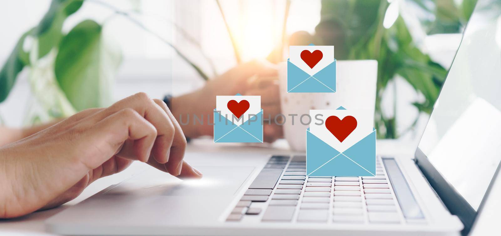 Hand typing keyboard with laptop computer with social media love letter mail send out icons valentine day. by Suwant