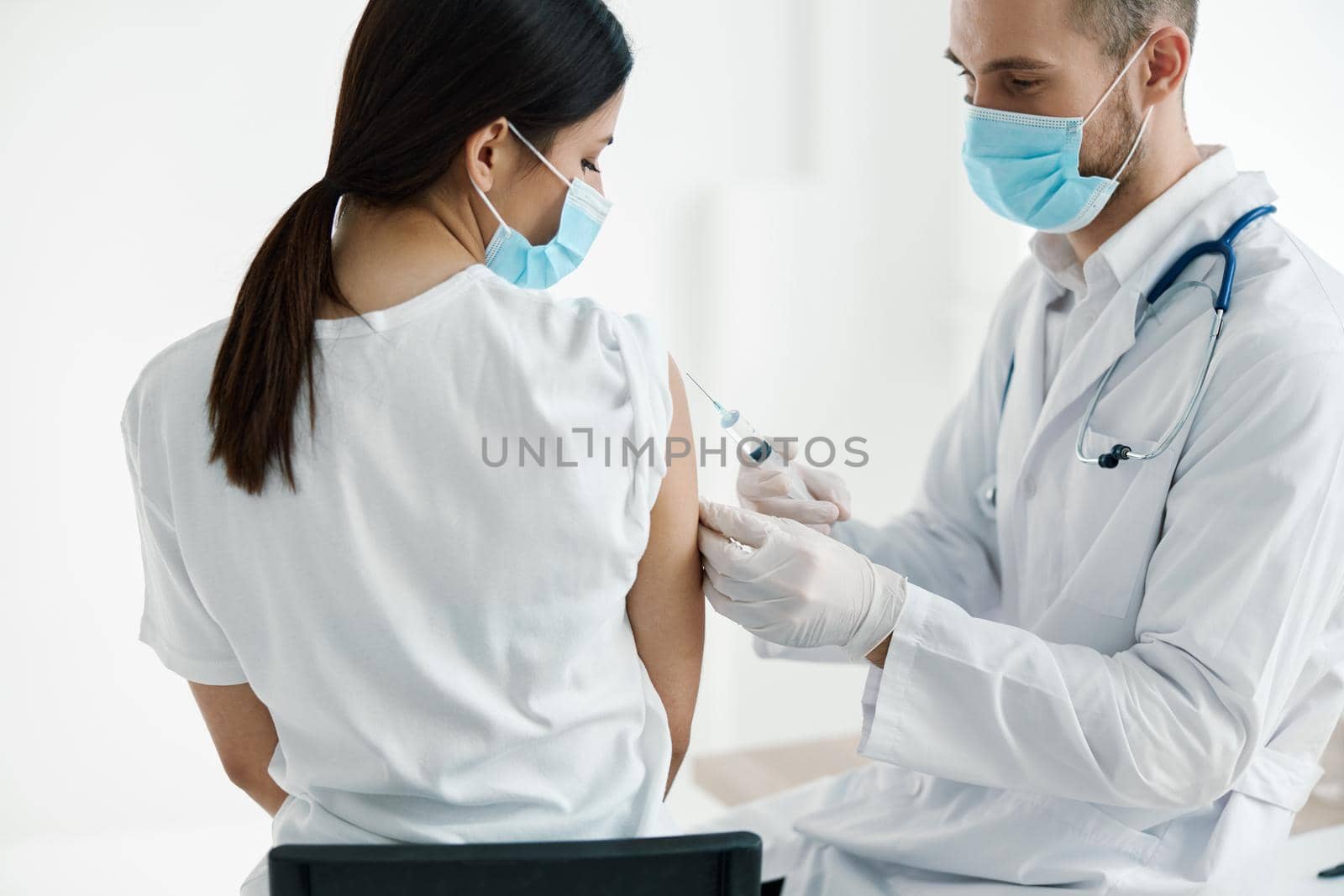 doctor in medical mask injecting vaccine on woman's shoulder epidemic hospital by SHOTPRIME