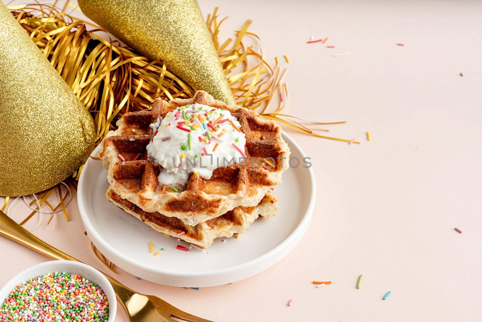 Birthday party waffles decorated with youghurt and colorful sprinkles