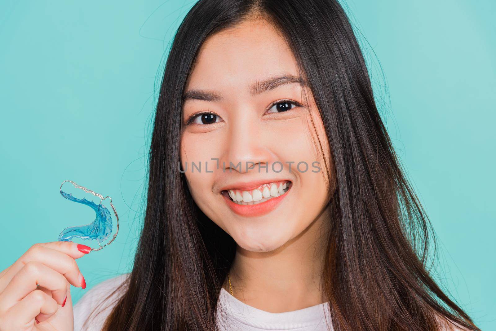 Portrait young Asian beautiful woman smiling holding silicone orthodontic retainers for teeth, Teeth retaining tools after removable braces, Orthodontics dental healthy care concept 