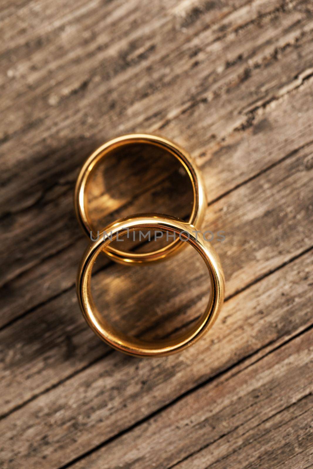 Two golden wedding rings on wooden background