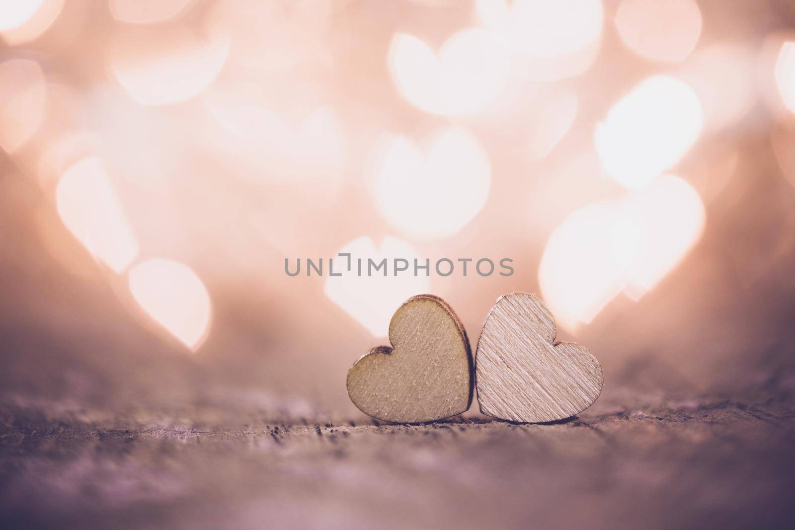 Two handmade wooden hearts on beautiful bokeh background. Vintage style. Love Valentine's Day concept.