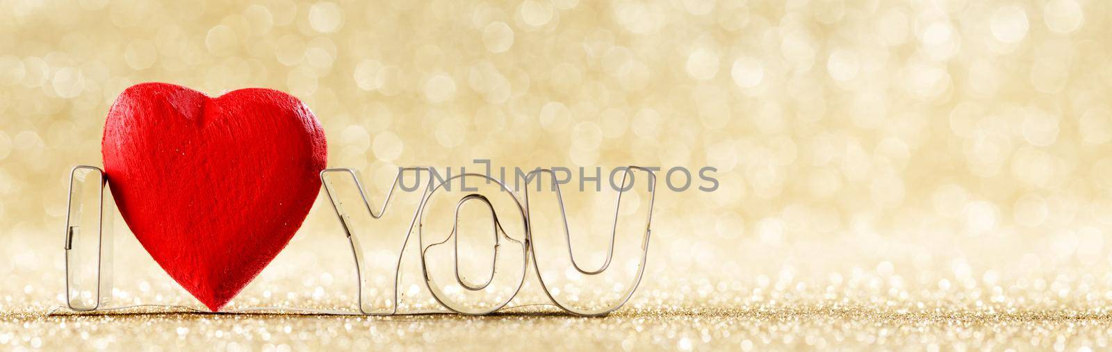 I love you and red handmade wooden heart on golden bright glitter lights bokeh background