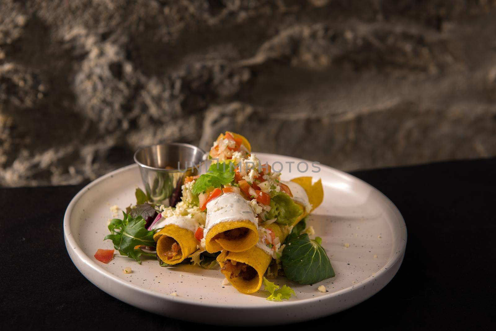 Mexican style pork flutes on white plate. Typical Mexican food.