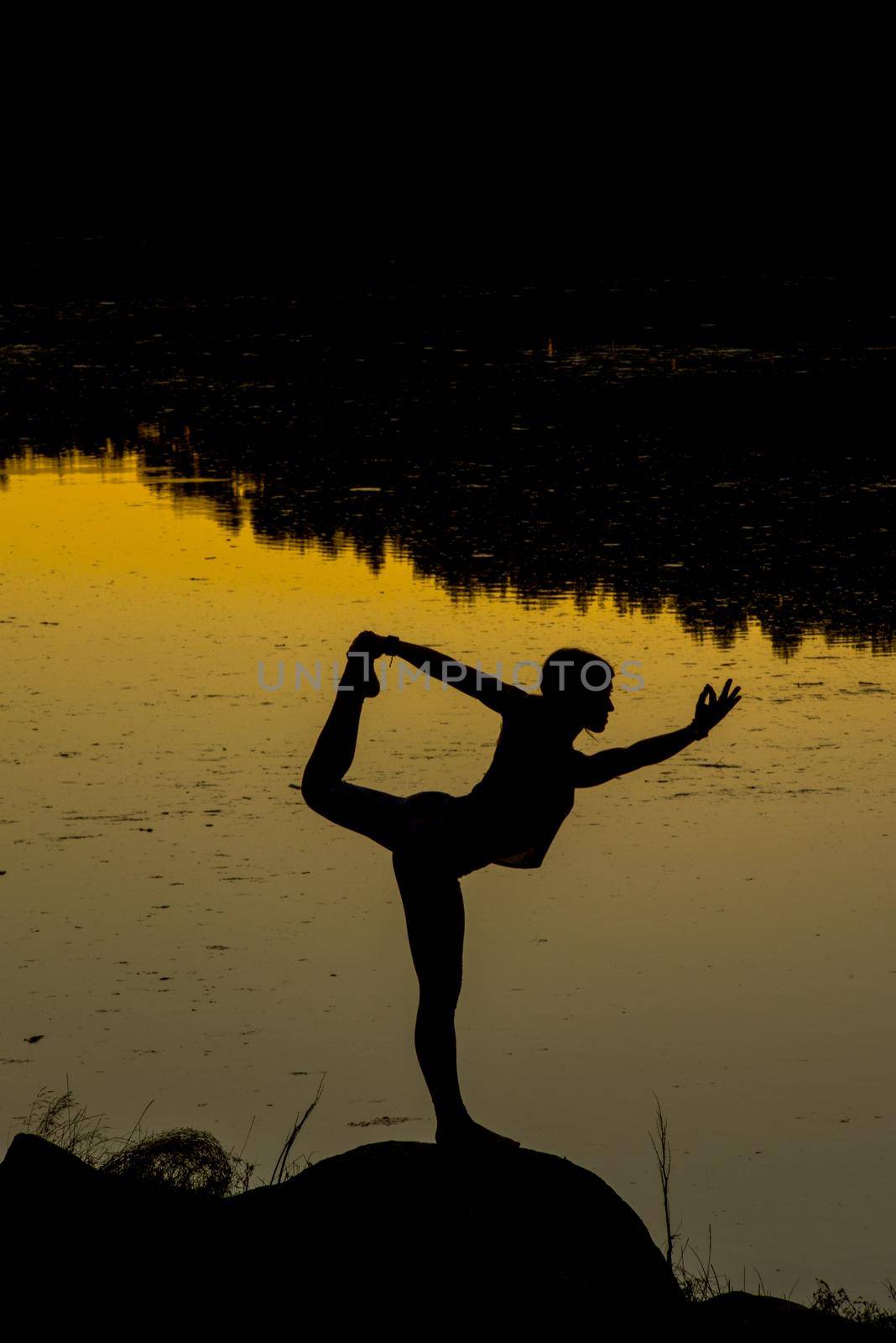 Silhouettes of a woman doing yoga at sunset by martinscphoto