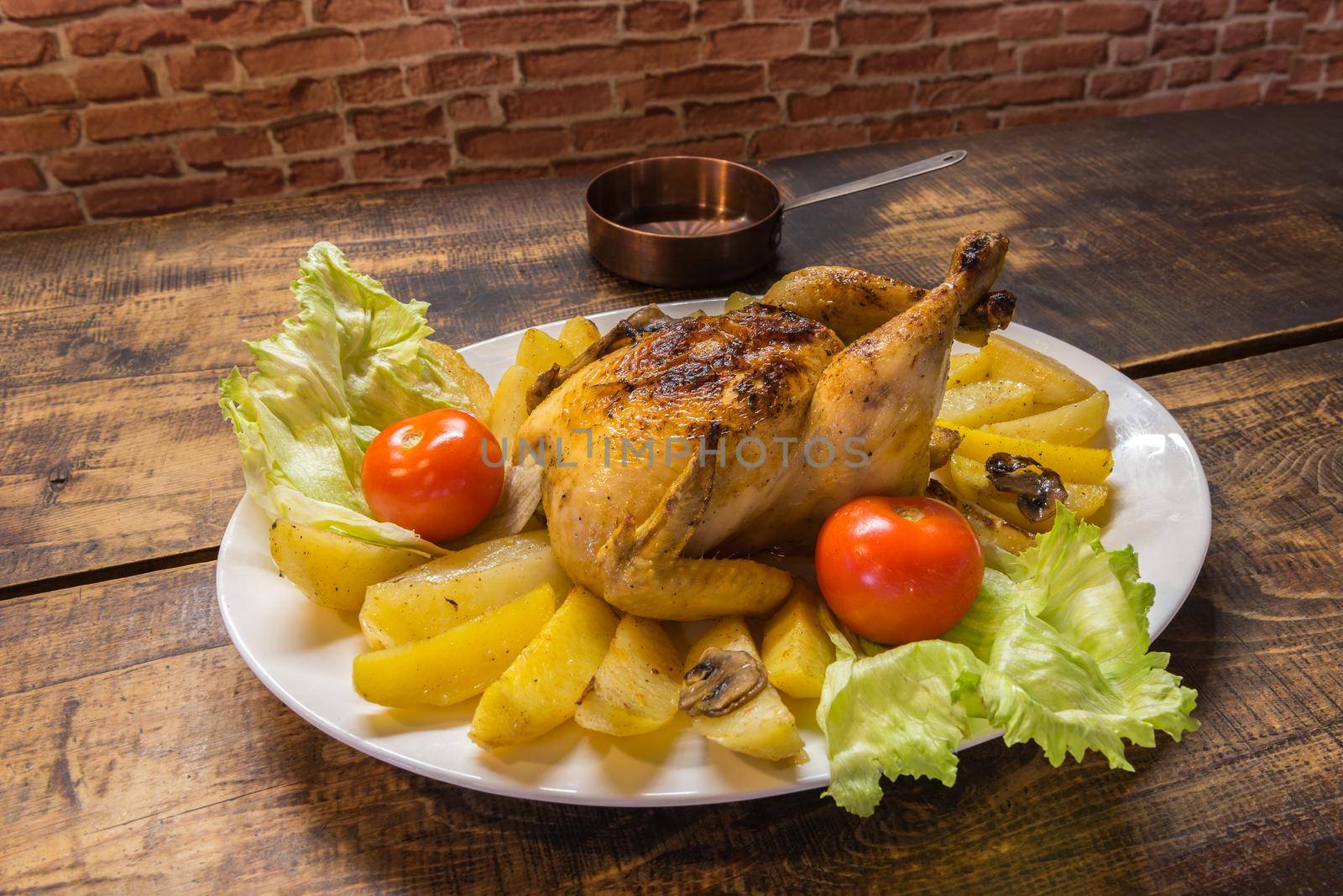 Chicken plate with potatoes with rustic wooden background.