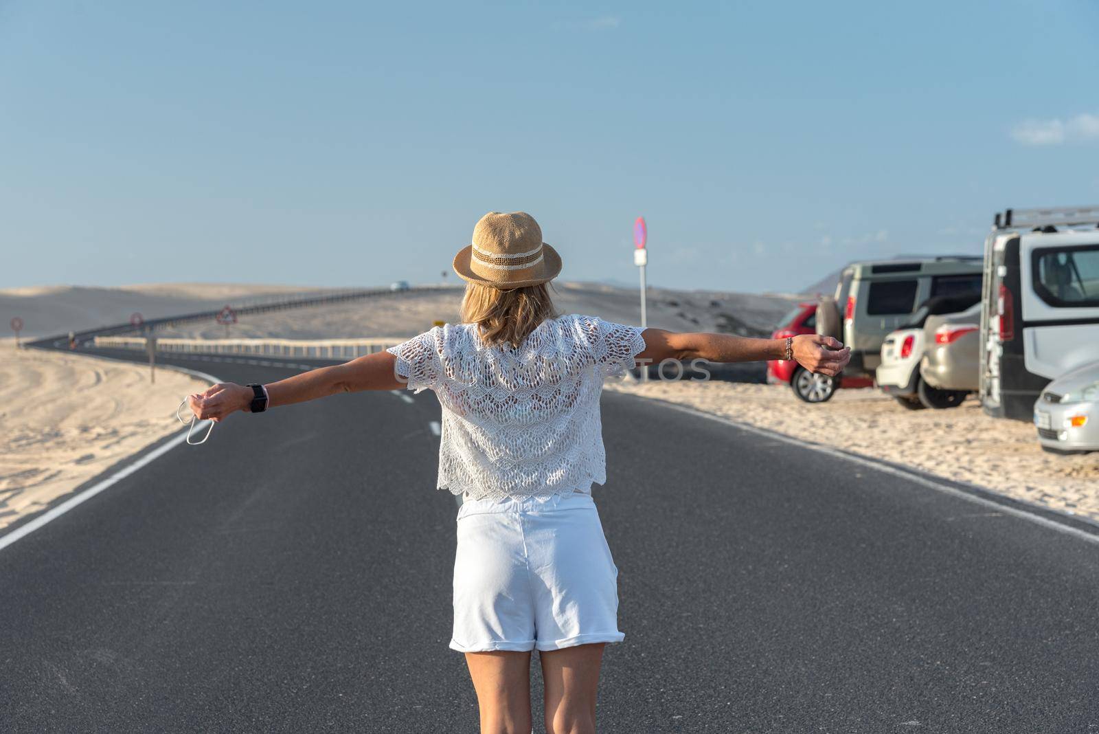 Corralejo, Fuerteventura, Spain: 2020 September 30: Blonde Tourist Girl with hat in the Parque Natual Dunas de Corralejo on Fuerteventura in Canary Islands in Spain.