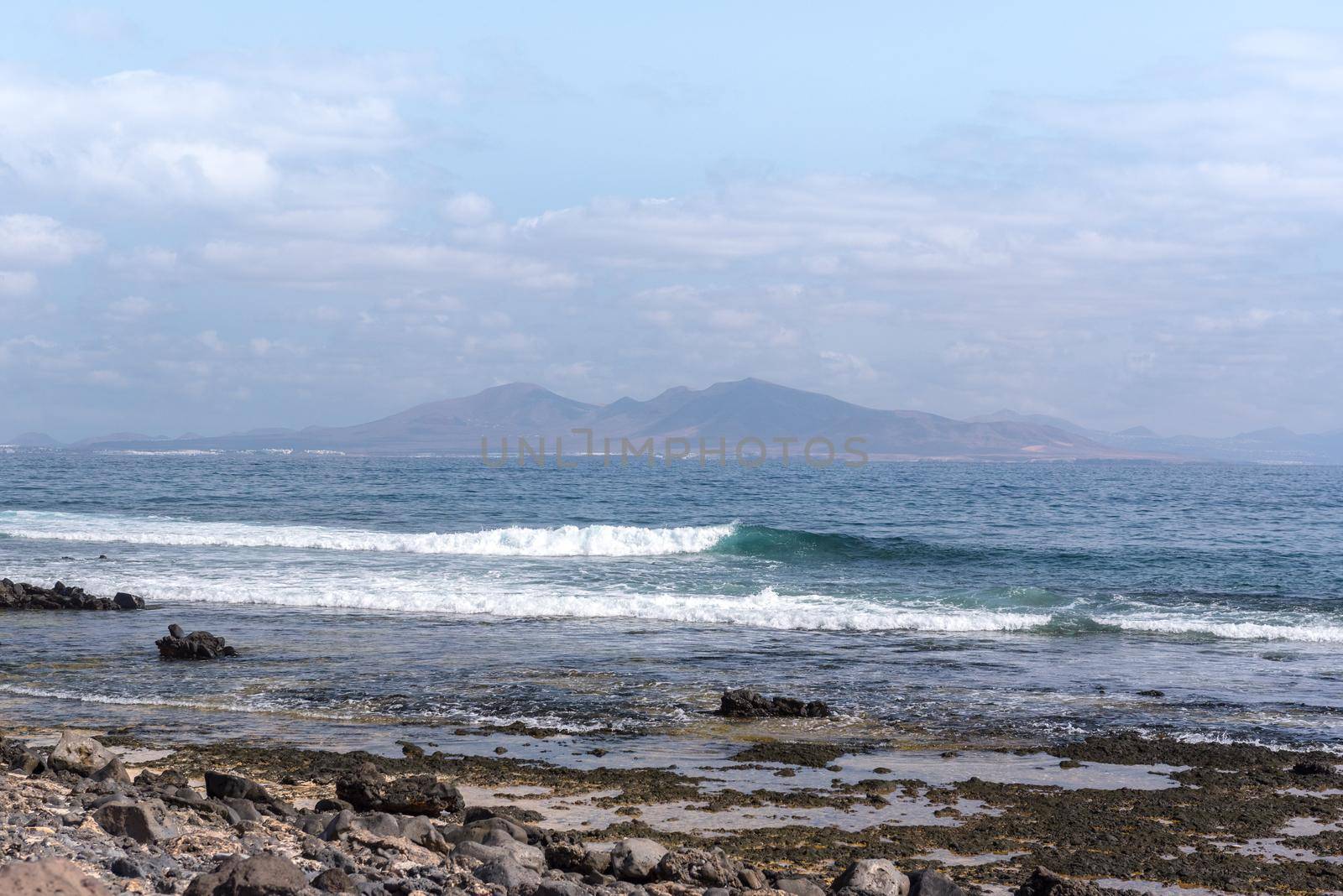 Sunny day on the coast of Fuerteventura where you can see Lanzarote in the distance in the Canary Islands in Spain.