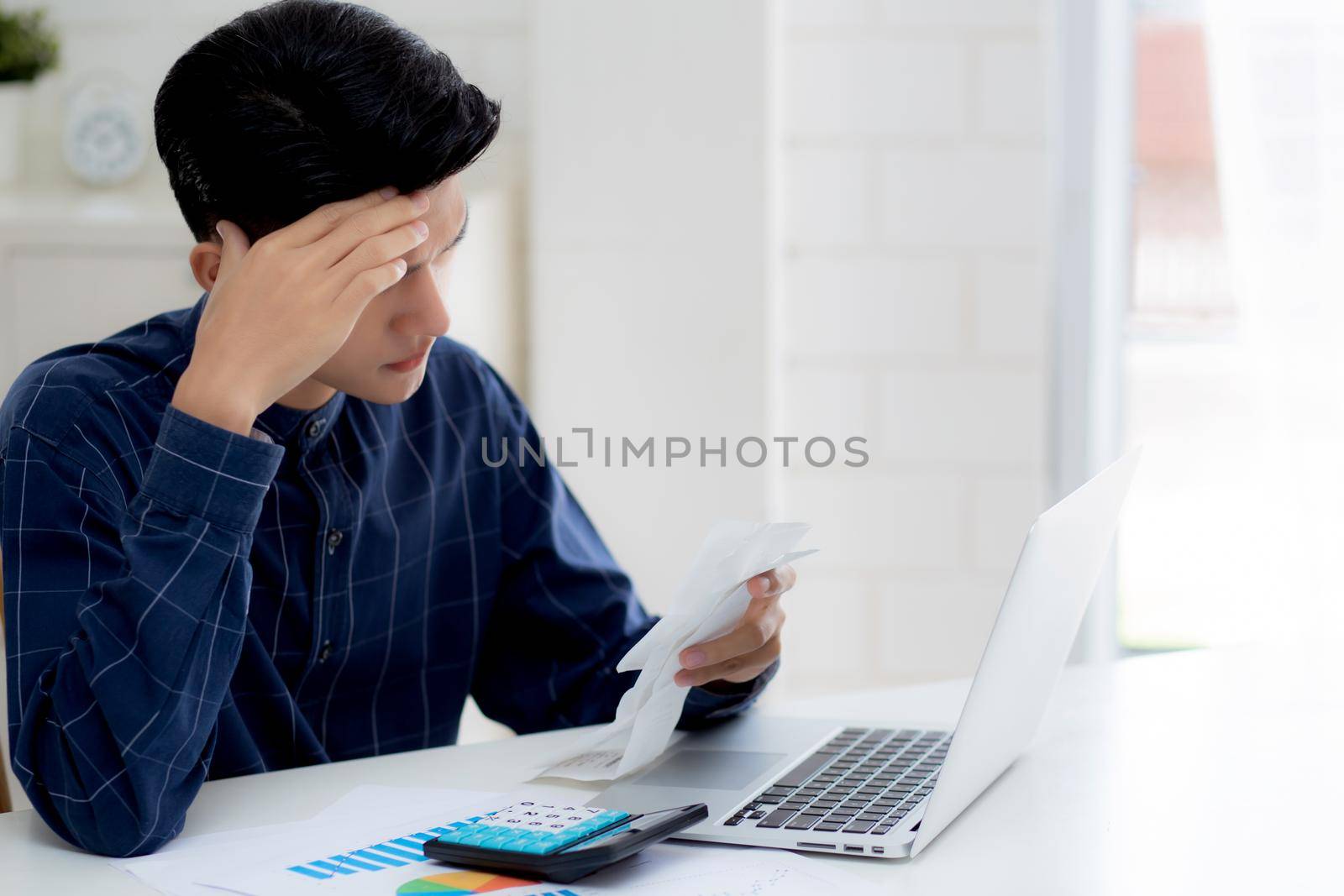 Young asian man calculating expenses household about finance and frustrated on desk at home, male checking bill having stress and worried, debt and tax, expression and emotion, business concept.