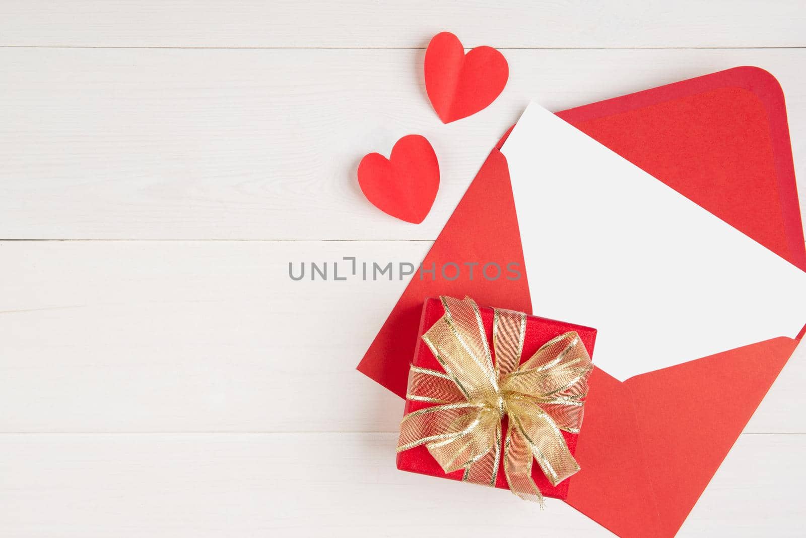 Blank postcard and letter and gift box and heart shape on wooden table, mockup greeting card and template, decoration with romantic, celebration and copy space, Valentine day and holiday concept.