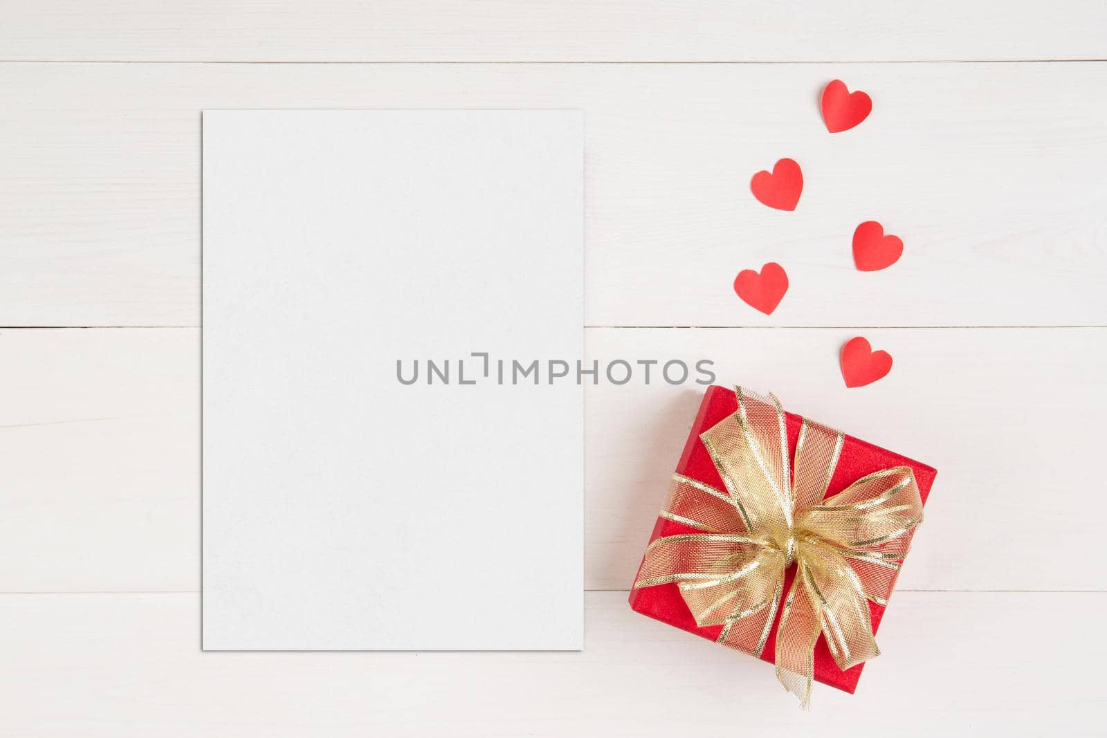 Blank postcard size a5 and letter and gift box and heart shape on wooden table, mockup greeting card and template, decoration with romantic, celebration Valentine day and holiday concept.