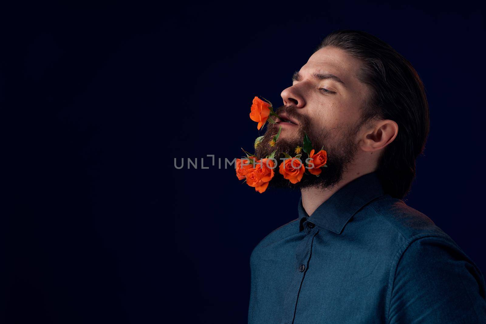Elegant man in a shirt flowers in a beard charm romance dark background. High quality photo