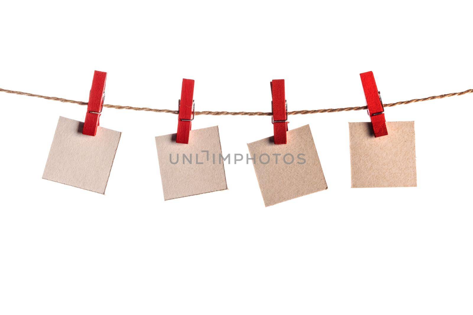 Four paper blank notes hanging on the rope isolated on white background