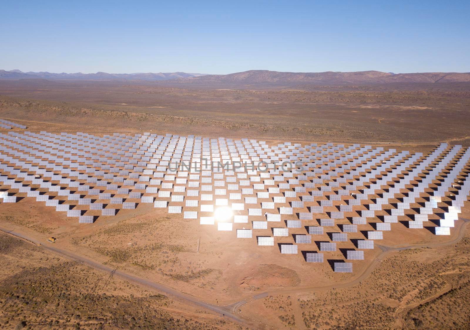 Aerial over solar panels in a dry landscape by fivepointsix