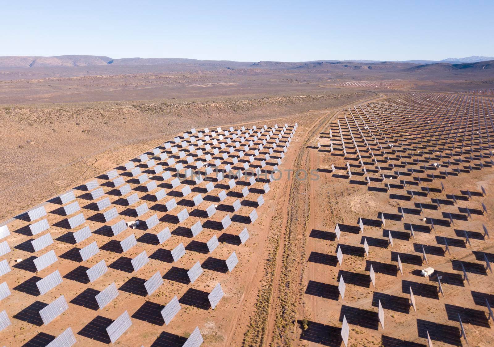 Aerial over solar panels in a dry landscape by fivepointsix