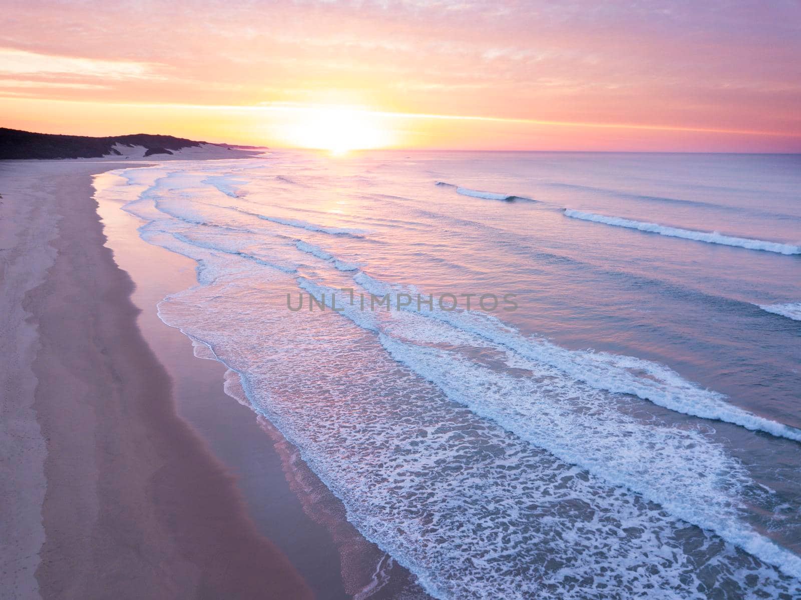 Aerial of sunrise over the ocean and empty beach