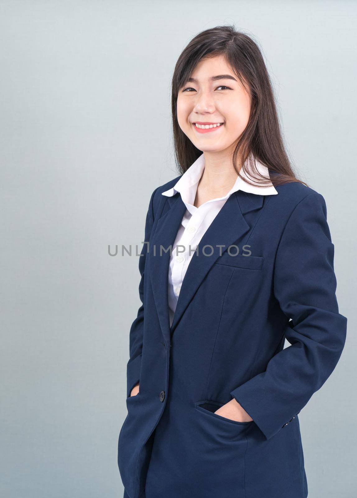 Portrait of asian business woman standing isolated on gray background