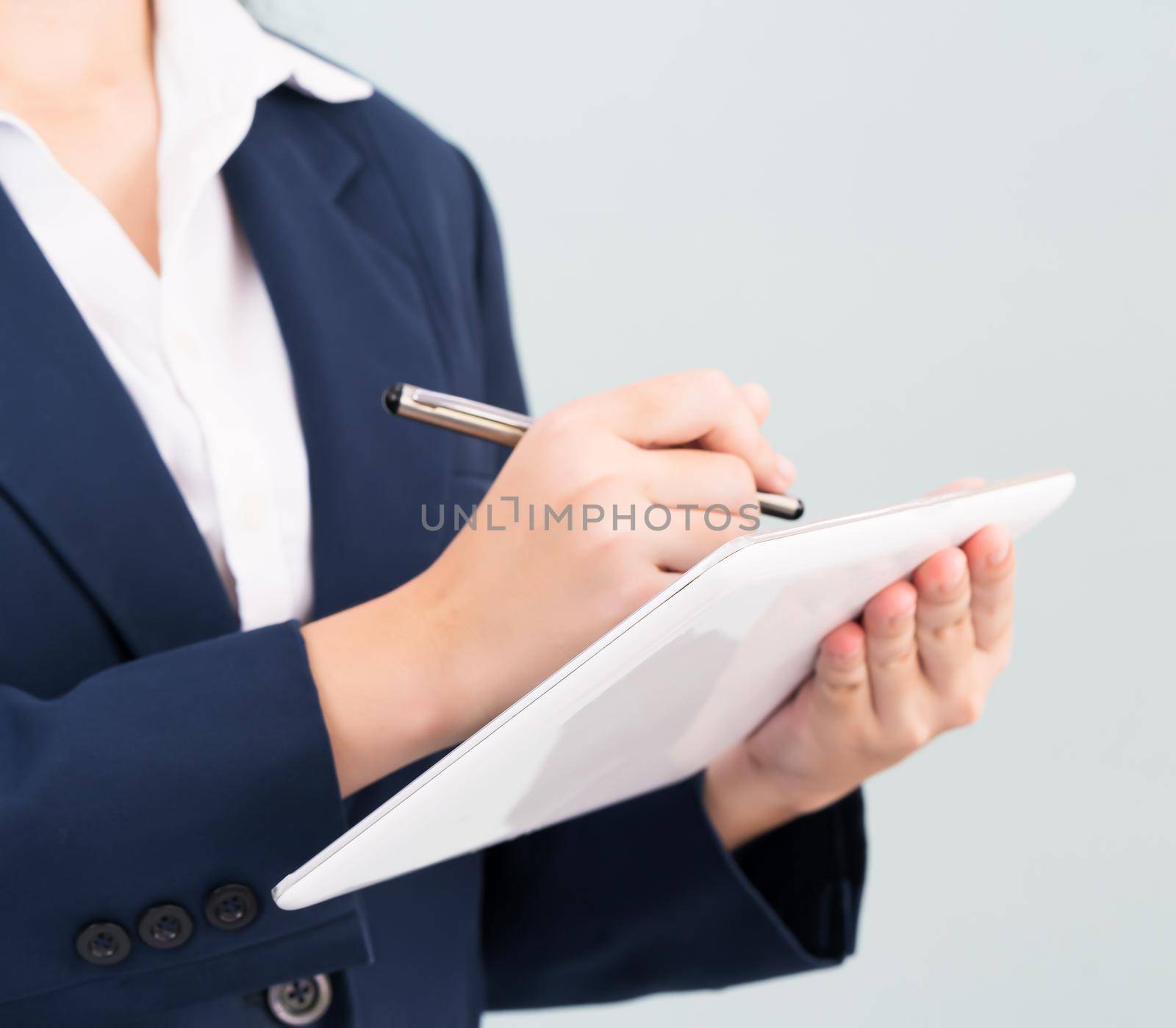 Woman in suit using computer digital tablet isolate on gray background