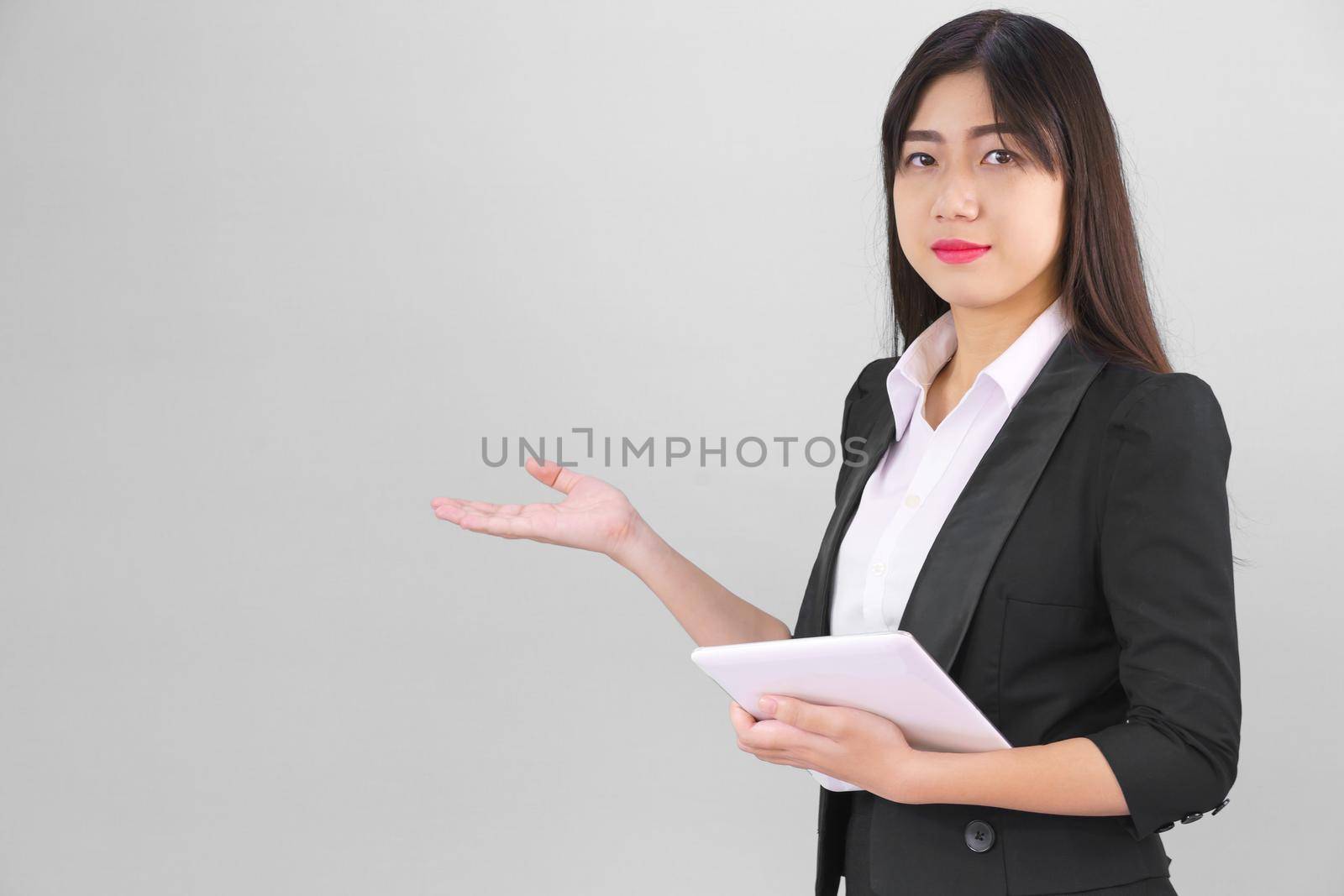 Young Asain women long hair in suit standing using her digital tablet computer  and pointing finger