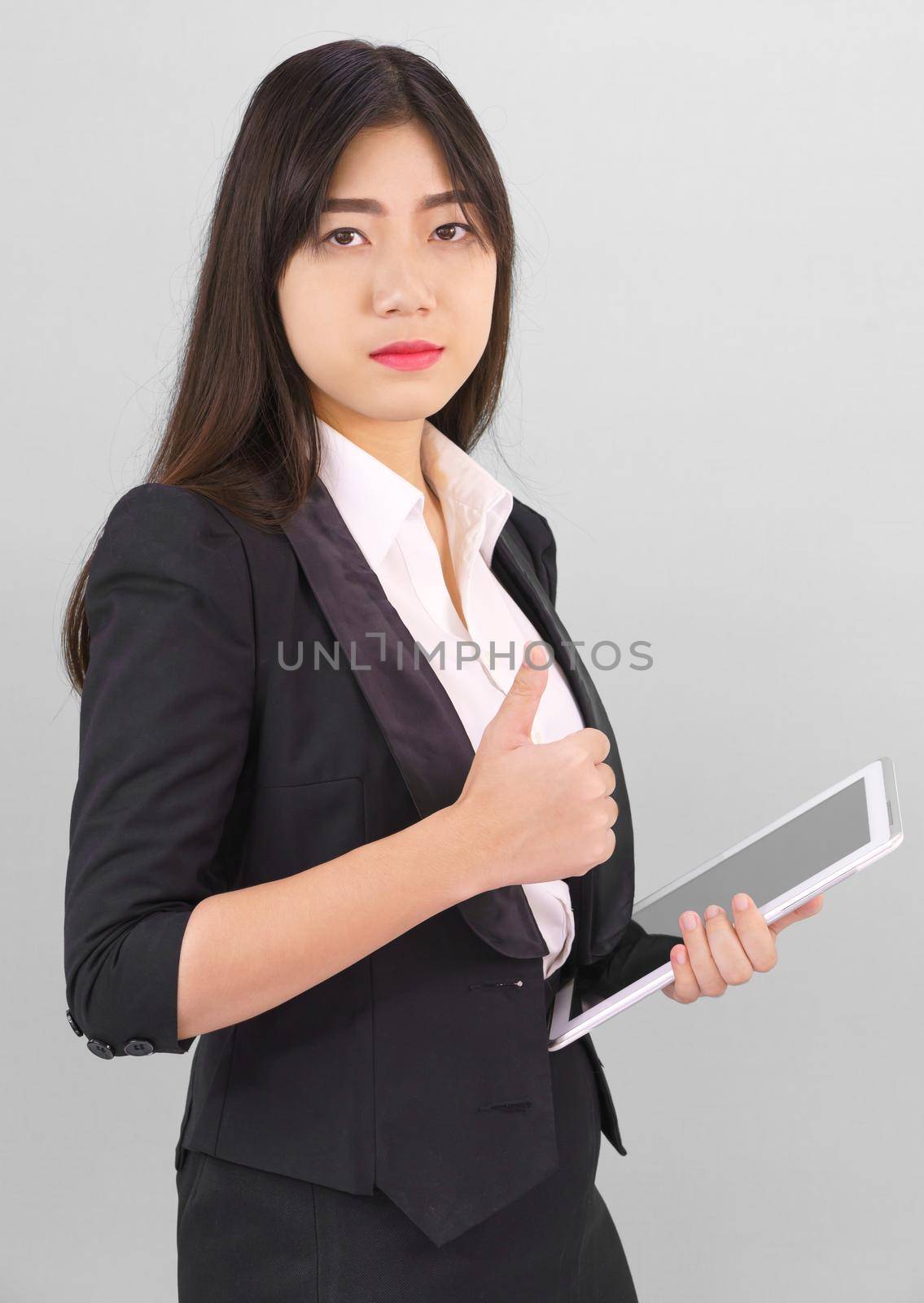 Young women standing in suit holding digital tablet by stoonn
